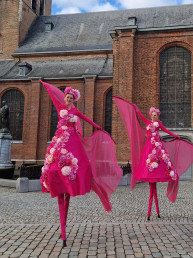 roze bloemen op stelten les steltenlopers fleurs levend entertainment moederdag lente steltenact